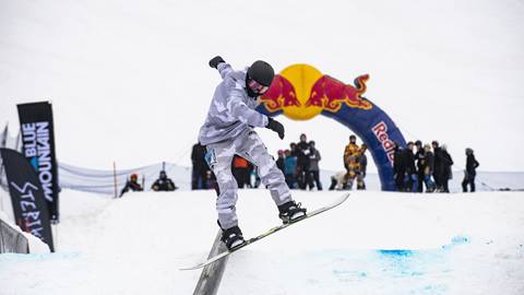 A snowboarder performing a trick on a rail at the Frozen Rail Jam Event at Blue Mountain Resort