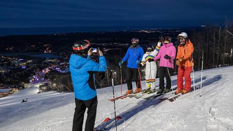 A group of people on skis taking a picture at night.