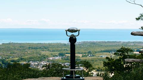 A statue on top of a hill with a view of the ocean.