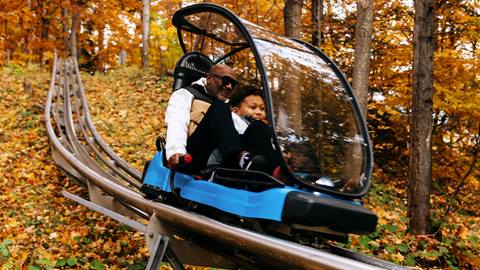 A father and son riding the Ridge Runner Mountain Coaster