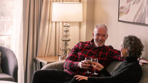 a couple drinking wine in their hotel room at The Westin Trillium House at Blue Mountain Resort