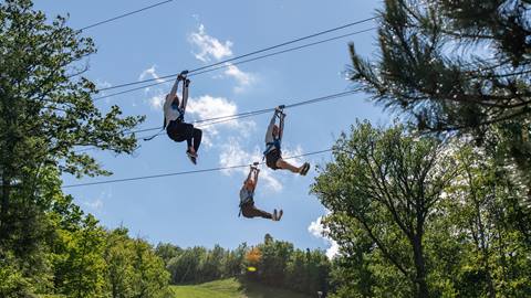 Three people enjoying the Wind Rider Triple Zips at Blue Mountain Resort