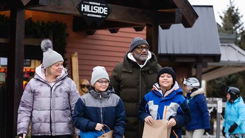 A family walking out of Hillside shop happy at the Blue Mountain Resort