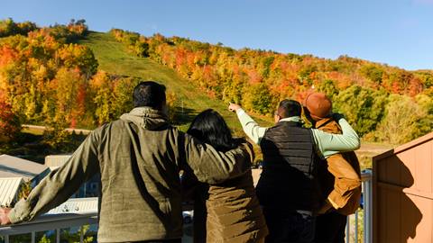 a family on their hotel balcony observing Blue Mountain Resort