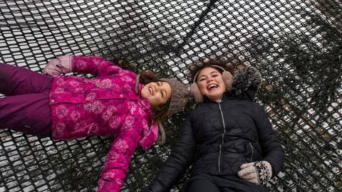 two girls enjoying the Canopy Climb Net Adventure in the Winter Time