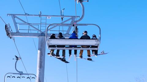 A group of people riding up a chairlift