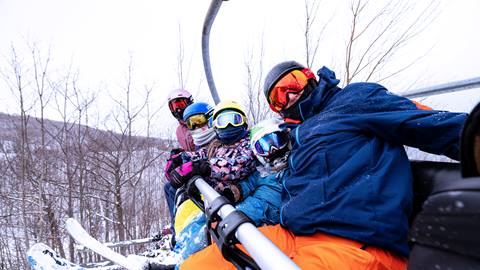 A family riding up a chairlift