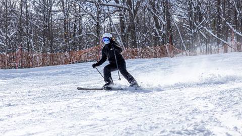 A woman skiing down Dr. Doug Trail