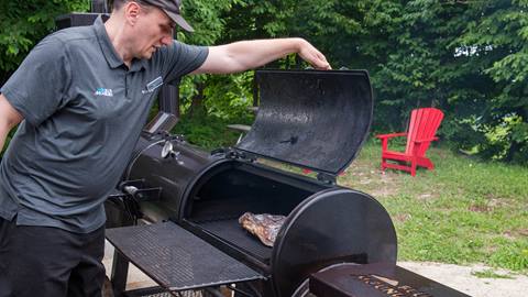Blue Mountain Resort Employee putting meat on a grill