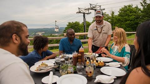 a group of people sitting at a table with food and drinks at Summitview Mountaintop at Blue Mountain Resort