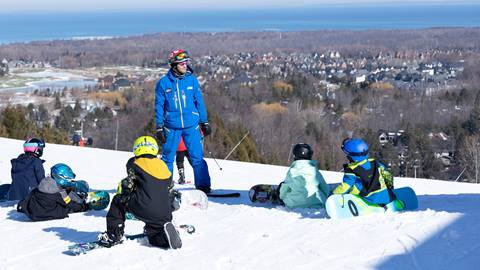 A group of people sitting on a snowy slope.