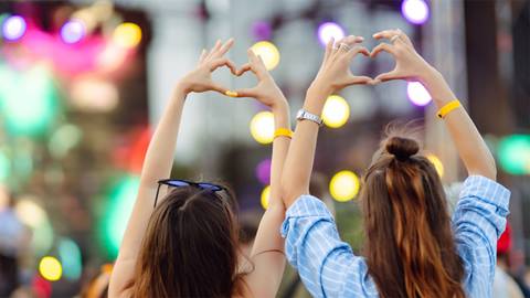 two girls making hearts with their hands at the Peak Party at Blue Mountain Resort