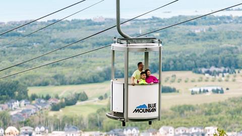 a family together on the gondola overlooking blue mountain village at blue mountain resort
