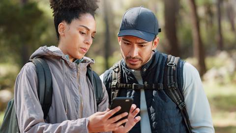 two people on a hiking trail using the blue mountain app to ensure they are on the correct hiking trail at blue mountain resort