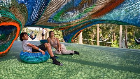 a boy and girl exploring the Cocoon Crawl Playscape Climbing Net