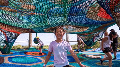 a group of adults enjoying the cocoon crawl climbing net at blue mountain resort