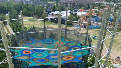 an image displaying the top tier of the cocoon crawl climbing net with a view of the adventure park at blue mountain resort