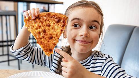 A girl holding up a piece of pizza