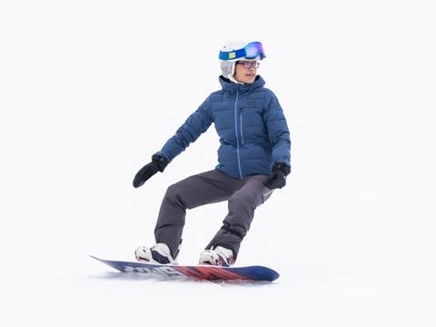 A person in a blue jacket and helmet is snowboarding on a snowy slope.