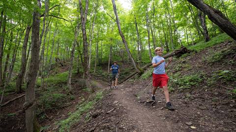 two youths enjoying a casual hike on a dirt trail at blue mountain resort