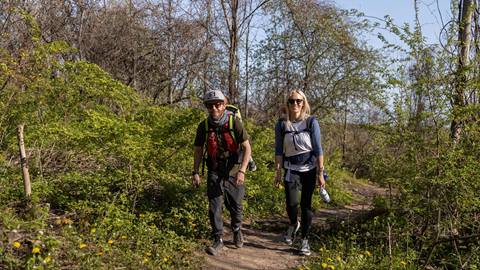 two people on a hiking trail with spring flowers blooming at blue mountain resort